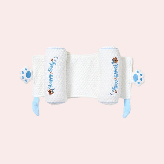 White adjustable baby pillow with a flat center panel, two side rolls, blue ties and paw-shaped tabs