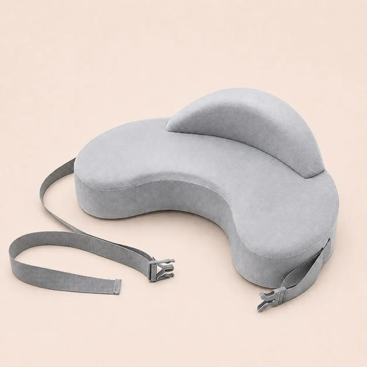 Charcoal-gray contoured nursing pillow with raised head panel and detachable buckle strap