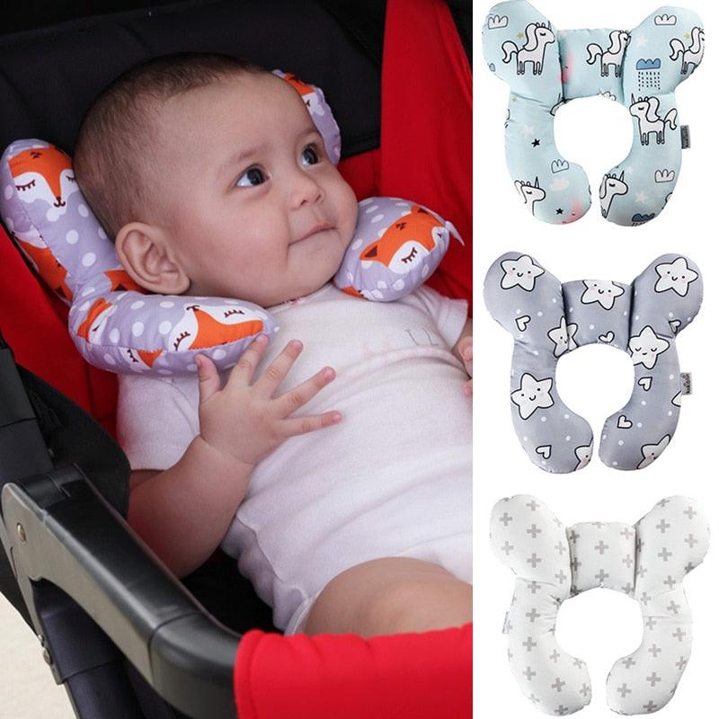 Butterfly-shaped printed baby pillow pictured behind an infant's head in a car seat