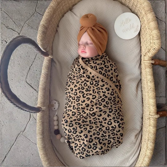 Leopard-print baby swaddle blanket with brown knotted hat in the current Shopify featured scene