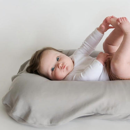 Infant resting comfortably on a gray baby lounger cushion