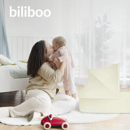 Mother with infant beside the portable baby nest lounger
