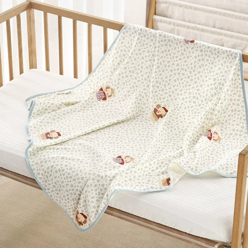 100% organic knit cotton baby swaddle blanket with cute cartoon pattern draped over a wooden newborn crib